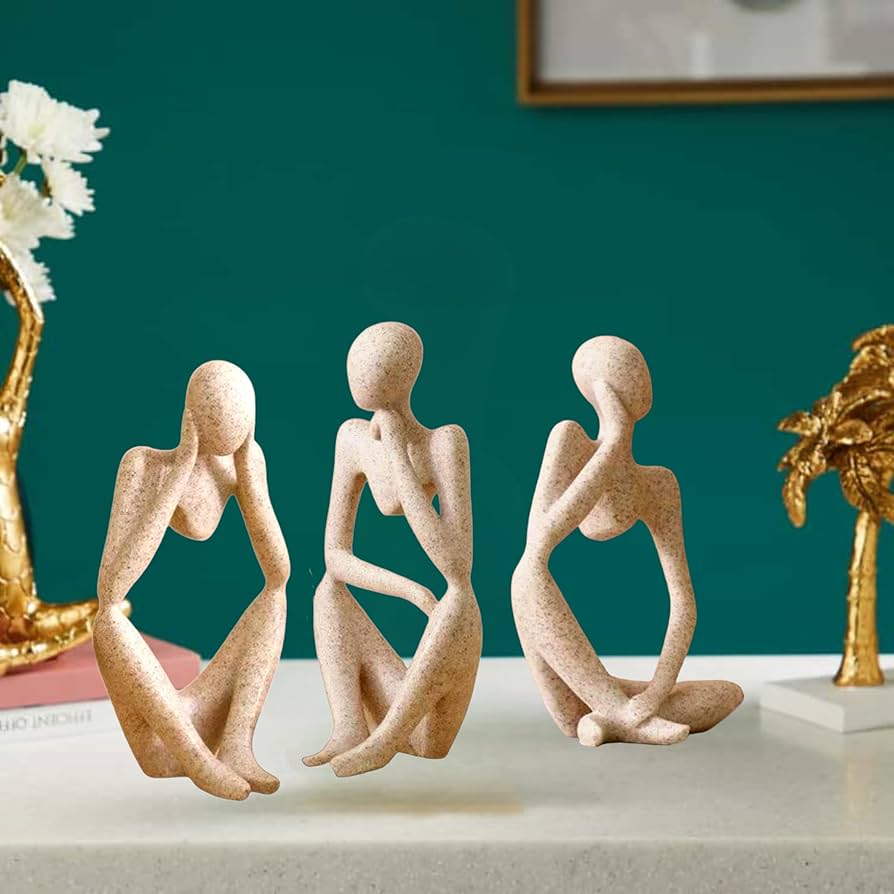 The Artment decorative abstract thinker resin showpiece set in silver styled on a modern living room shelf.